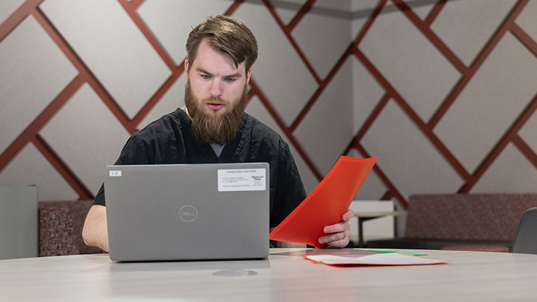 Professional working online with a folder in hand.