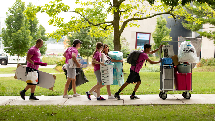 Students carrying their belongings with family