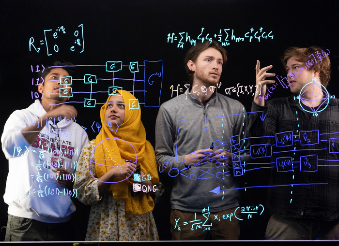 Students work out a problem on a dry erase board