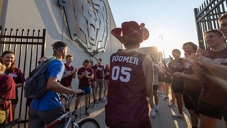 A group of students enter Plaster Stadium for Play Fair as the sun sets.