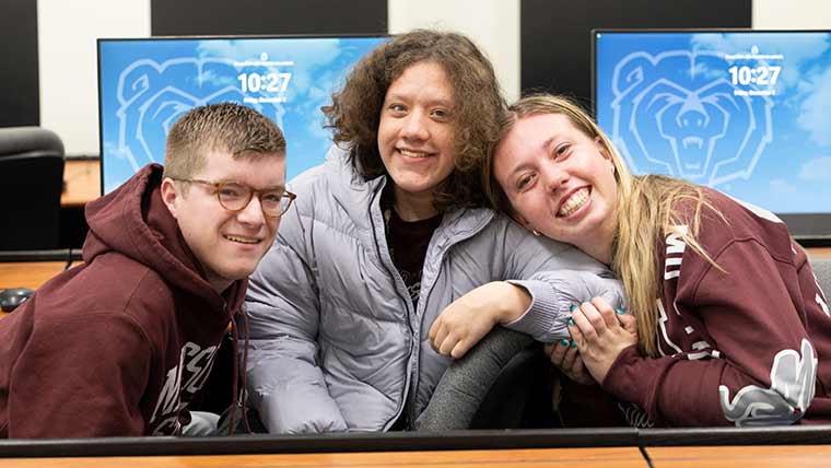 A Bear POWER student with two ambassadors take a photo together.