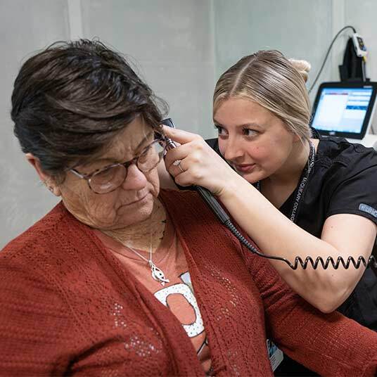 Student Alyson Morgan uses an otoscope to check her patient's ear health.