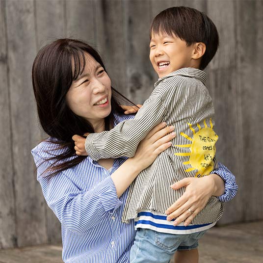 Dr. Hailey Choi, a assistant professor in Missouri State's School of Teaching, Learning and Developmental Science, smiles at her child as she holds him.
