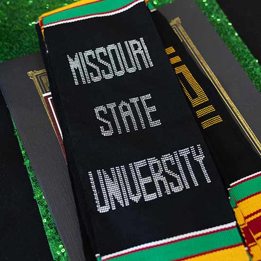 A black Missouri State scarf with green and gold stripes.