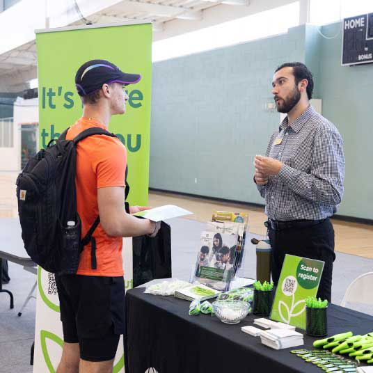 A student discusses his job qualifications with a business manager at a student employment job fair.