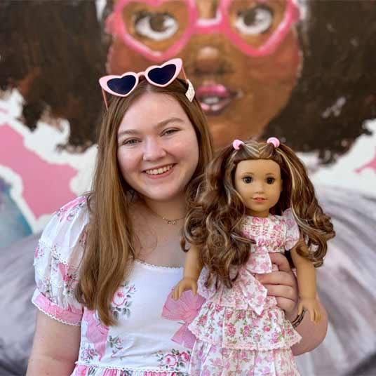 Mal Grant, a senior majoring in management and leadership at Missouri State, matches pink outfits with the American Girl doll she is holding.