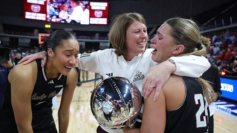 Missouri State coach Beth Cunningham hugs two players postgame after winning the Conference USA Tournament.