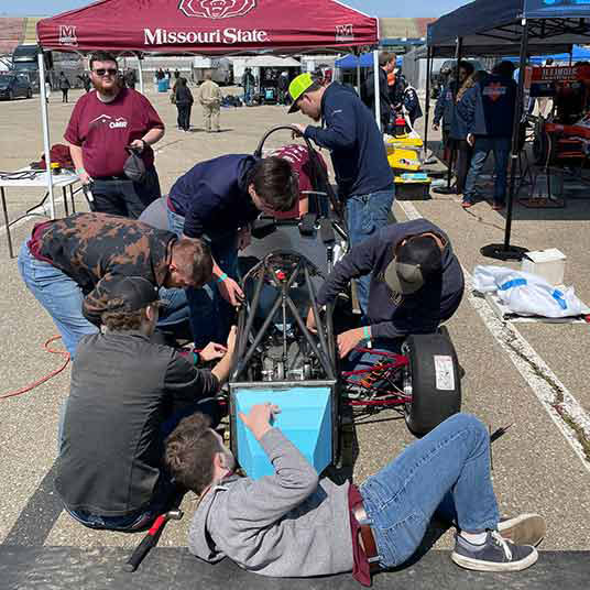 Engineering students assemble their car for the Formula SAE racing competition.