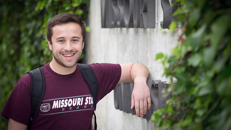 Smiling Missouri State student with backpack on the Missouri State campus. 