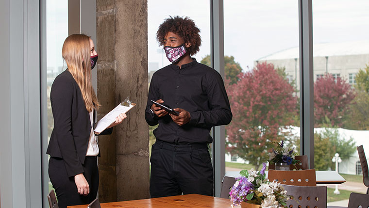 Two Missouri State students discussing their work tasks.