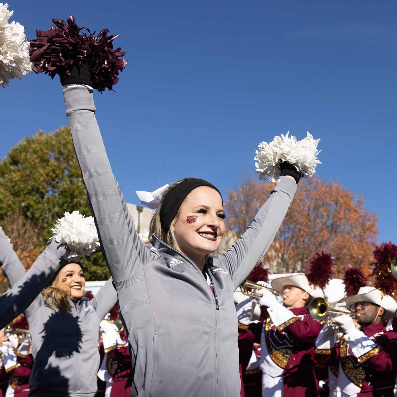 Missouri State cheerleaders and band performing at a homecoming ceremony.